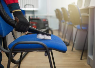 a professional cleaner man in uniform removes an office space with the help of an industrial vacuum cleaner. Cleaning services.