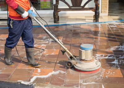 People cleaning floor with machine.